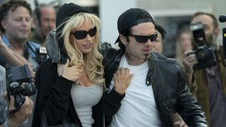Tommy Lee and Pamela Anderson wade through a press mob in the Pam and Tommy TV series