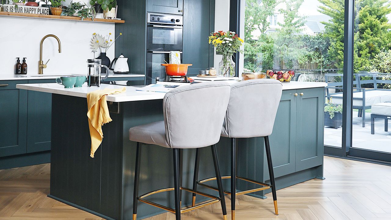 kitchen with wood herringbone floor and blue island and cabinetry and patio doors