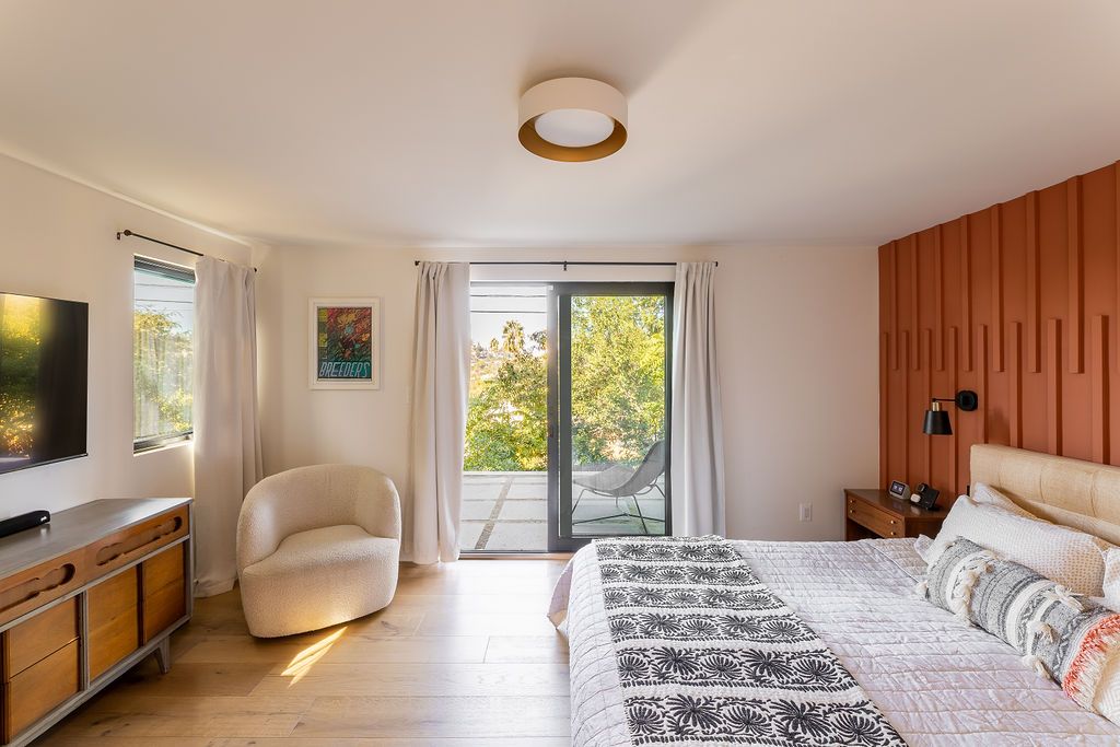 A modern bedroom with a red panelled accent wall