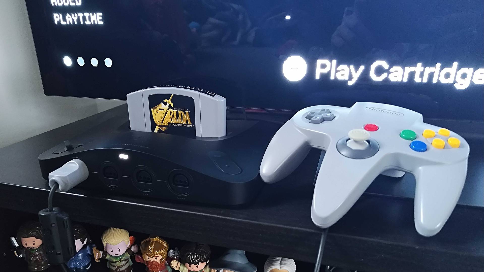 Analogue 3D with Zelda: Ocarina of Time cartridge inserted on black unit next to TV