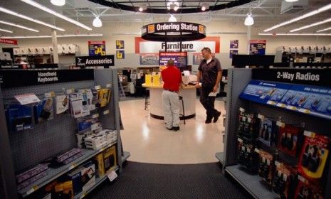 A Staples employee assists a customer in San Jose, Calif.: Staples is closing 15 of its U.S. stores and even more across the globe.