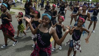 Members of Divaz dance group join participants in the Juneteenth Music Festival and parade on June 17, 2017 in Denver, Colorado. Organizers say that this is one of Denver's longest-running parades, dating back to the 1950s.