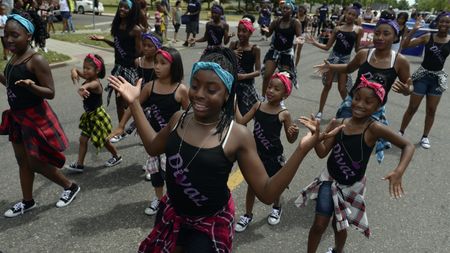 Members of Divaz dance group join participants in the Juneteenth Music Festival and parade on June 17, 2017 in Denver, Colorado. Organizers say that this is one of Denver's longest-running parades, dating back to the 1950s.