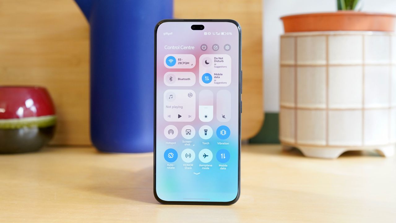 A vertical photo of the Honor 400 Pro against a background of objects showing off the front of the phone