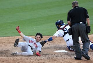 Red Sox outfielder Andrew Benintendi slides home just ahead of Dodgers catcher Yasmani Grandal's tag in an Aug. 7, 2016 interleague game at Dodger Stadium. Credit: Stephen Dunn/Getty Images