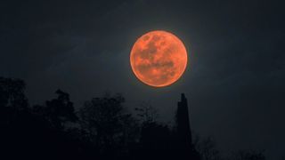 Blood moon full lunar eclipse over mountain in Thailand