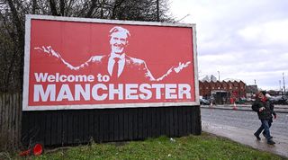A billboard showing partial Manchester United owner Sir Jim Ratcliffe outside Old Trafford.
