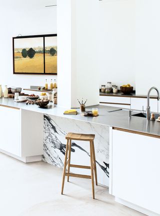 White kitchen with island and wood seating