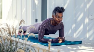 How to get abs: older woman doing a plank on an exercise mat