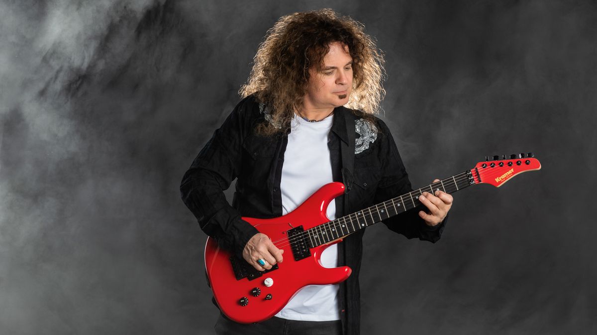 Vinnie Moore with a red Kramer electric guitar