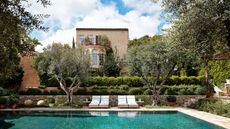 Exterior of house with pool, limestone paving and Mediterranean planting