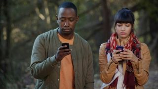 Lamorne Morris and Hannah Simone looking at phones in New Girl.