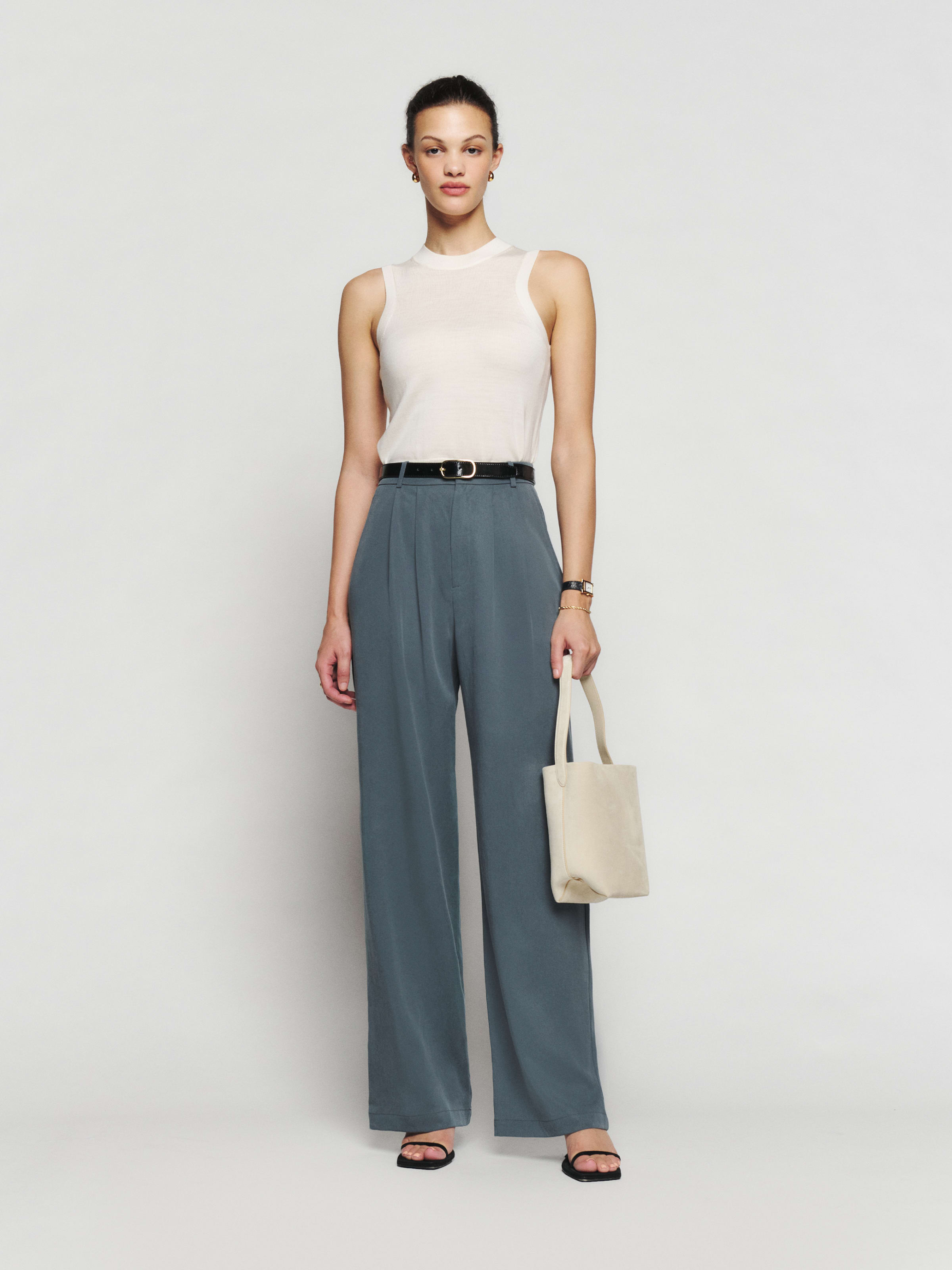 a model wears the Reformation Mason Pant in front of a plain backdrop