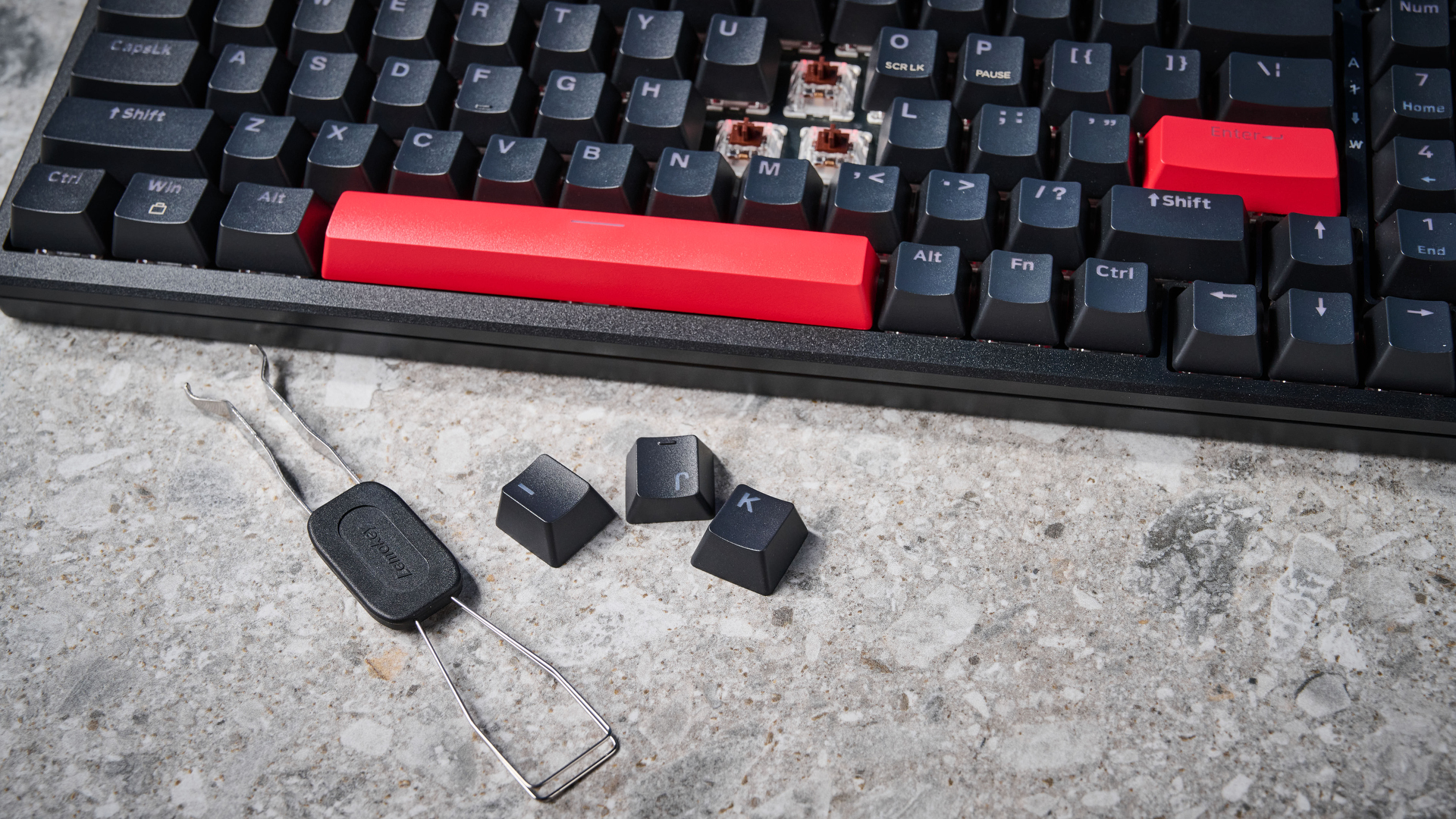 A black Lemokey X5 wired mechanical keyboard with red and black keycaps