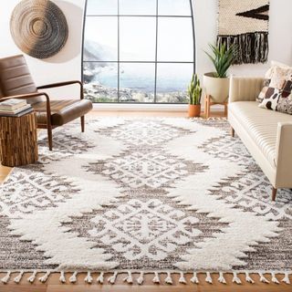 A Moroccan-inspired rug in brown and white, with a tribal design and tassles