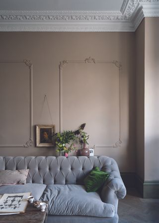 A studded sofa with a pale warm grey wall backdrop