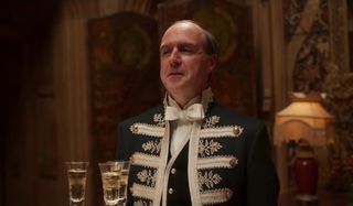 Downton Abbey Molesley stands with a tray of champagne to serve the royals