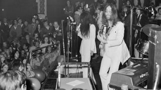 John Lennon (1940 - 1980) and Yoko Ono performing with the Plastic Ono Band at the Lyceum Ballroom, London, 15th December 1969. Guitarists Eric Clapton and George Harrison can be seen in the background