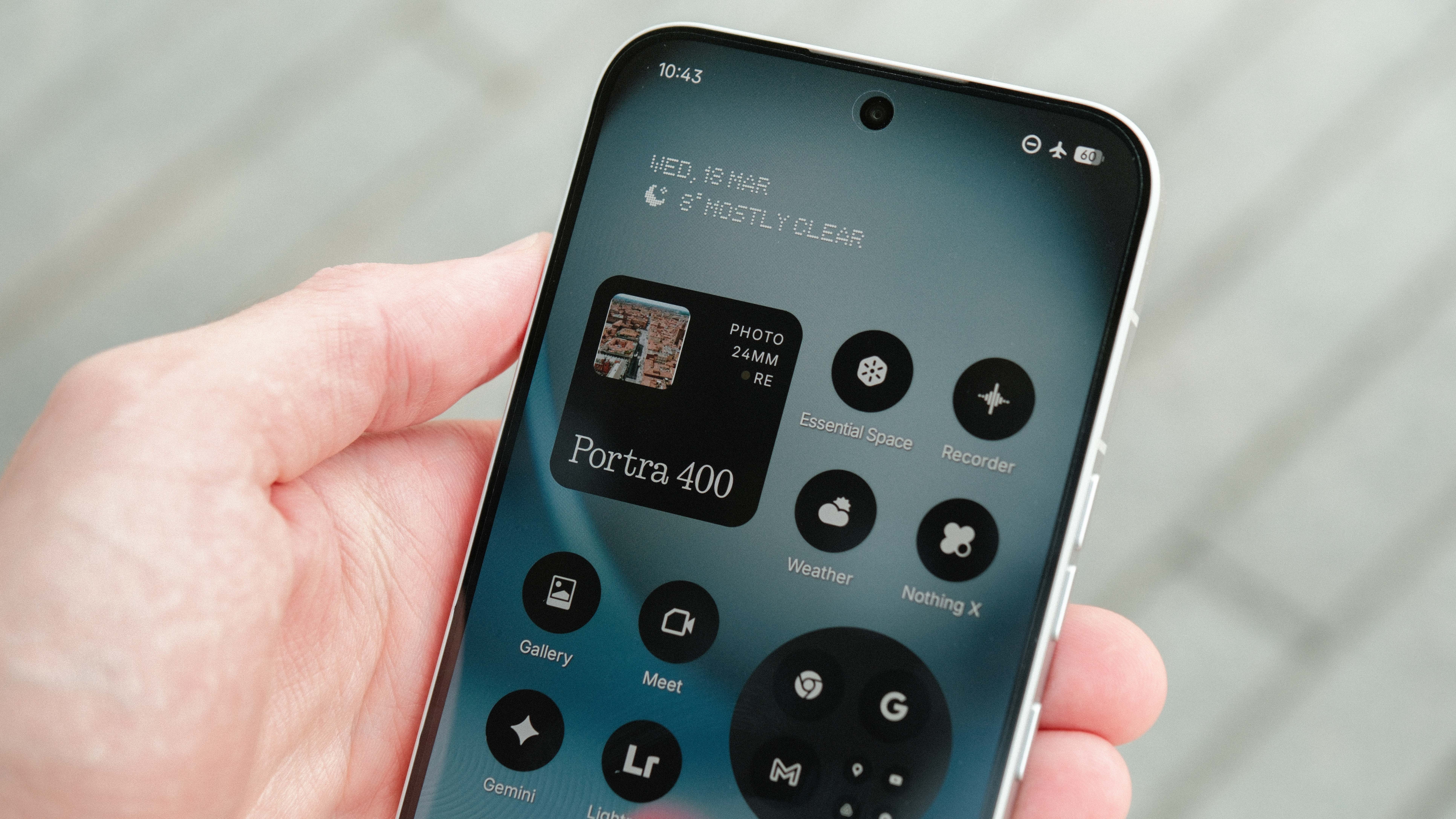 A detailed close-up of a smartphone screen showing a custom Android interface with various circular monochrome widgets, including "Weather," "Recorder," and "Nothing X," alongside a larger "Portra 400" photo widget.
