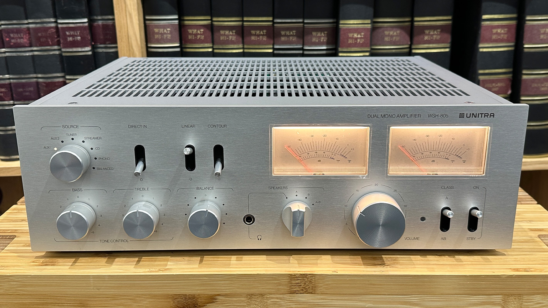 Unitra WSH-805 integrated amplifier on wooden hi-fi rack in front of bookcase