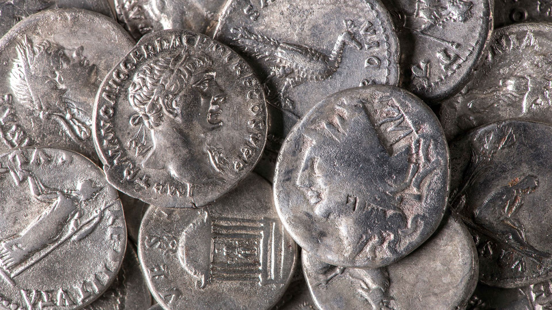 A close up of silver coins with various carvings in them.
