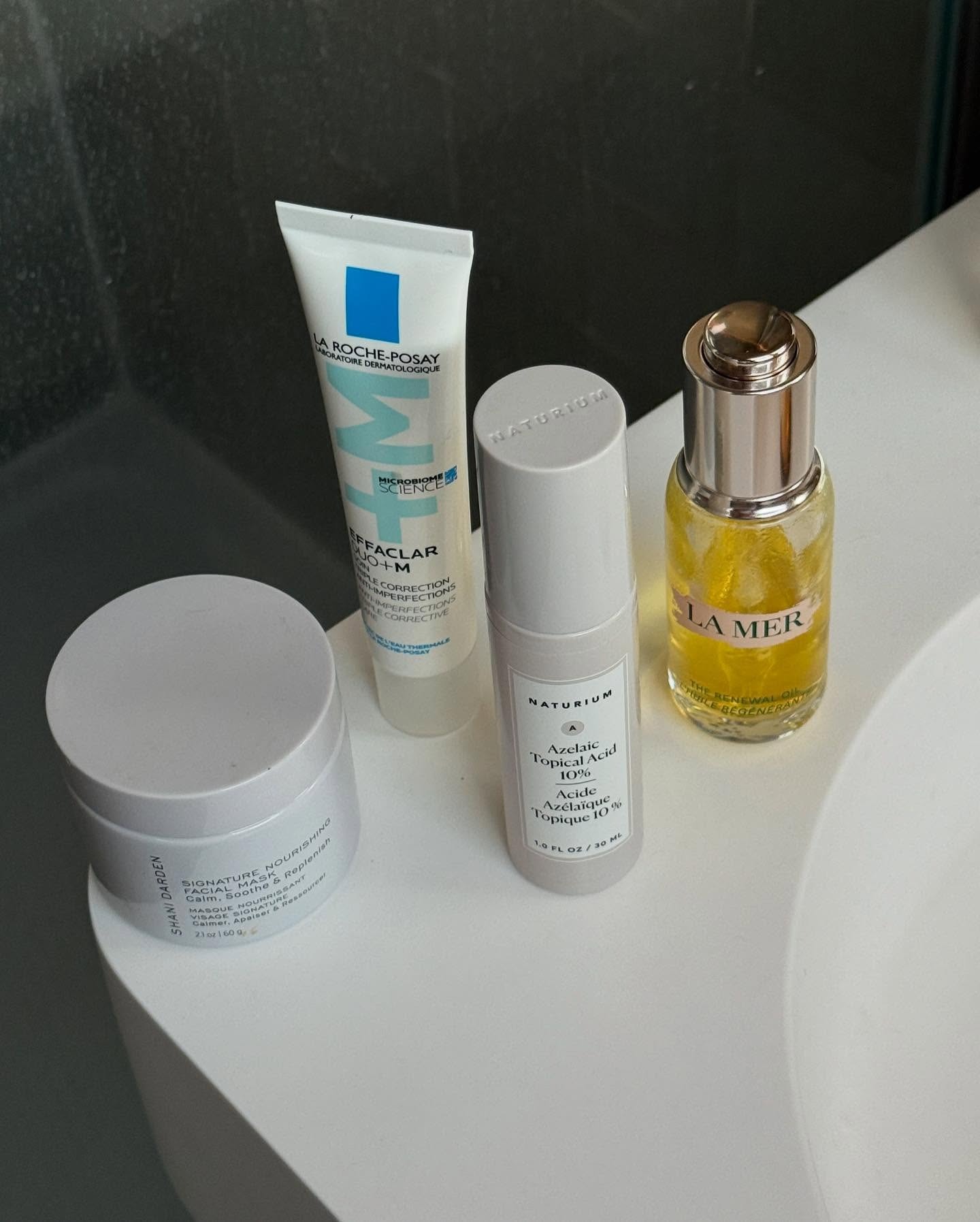 A close up of skincare products on a bathtub corner