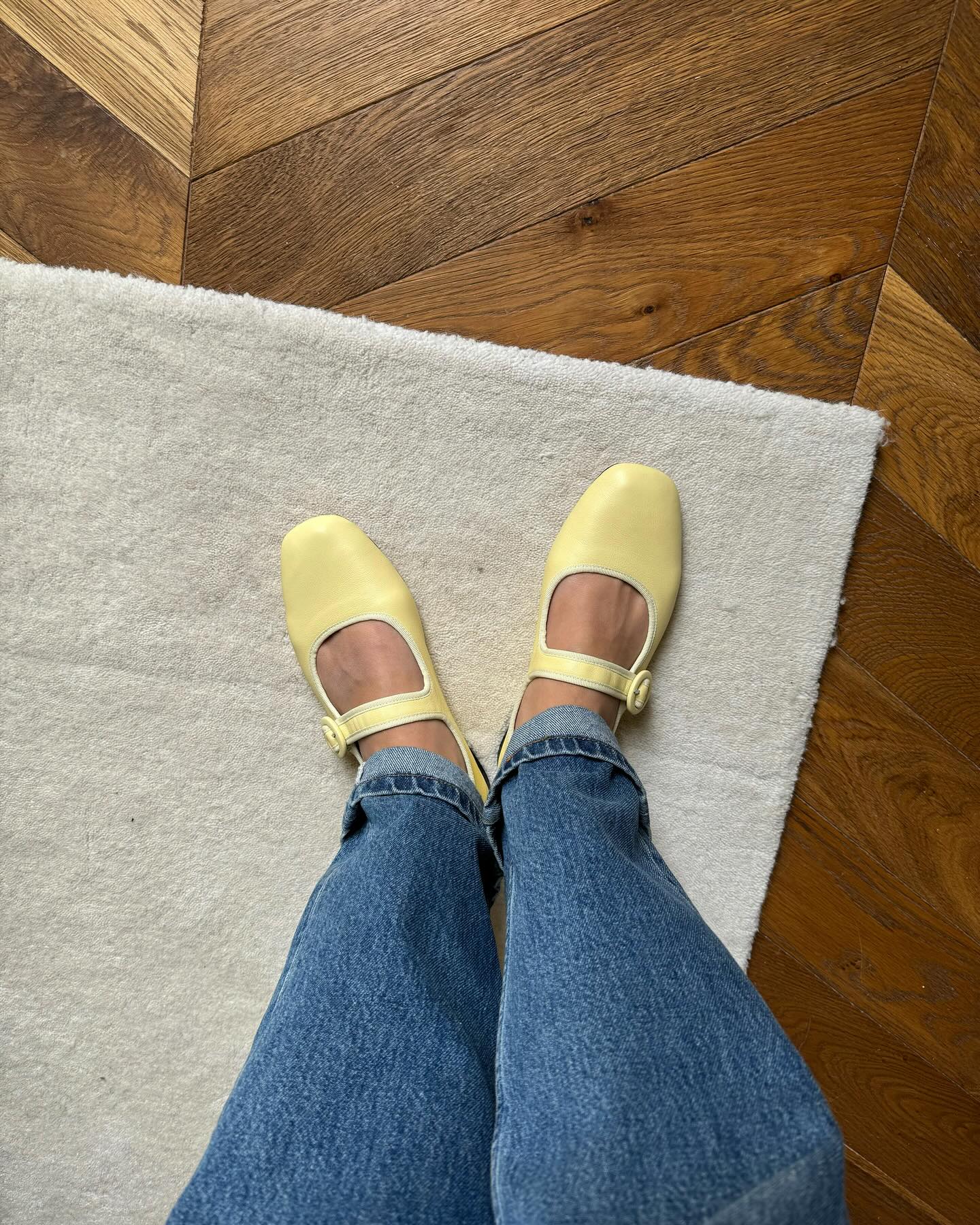 A woman wearing flat Mary-Janes with jeans