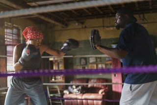 A female boxer (Ryan Destiny as Claressa Shields) spars with a coach (Brian Tyree Henry as Jason Crutchfield) wearing mitts, in director Rachel Morrison’s THE FIRE INSIDE.