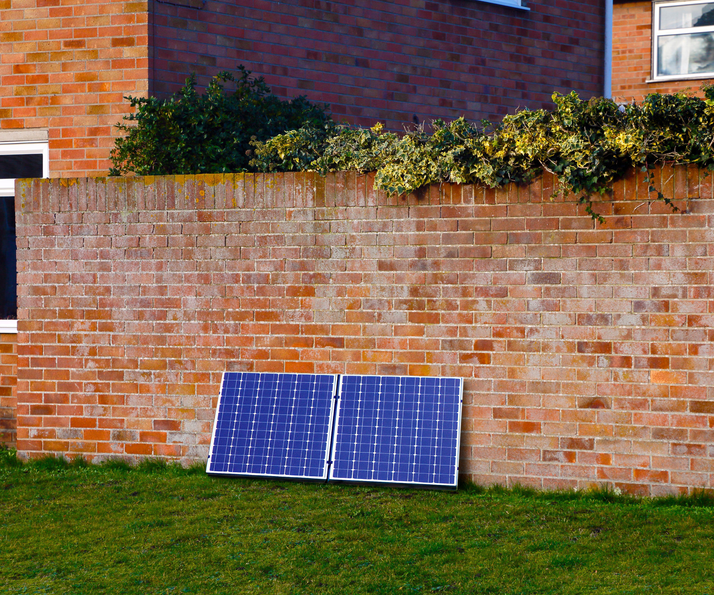 solar panels resting against a brick wall