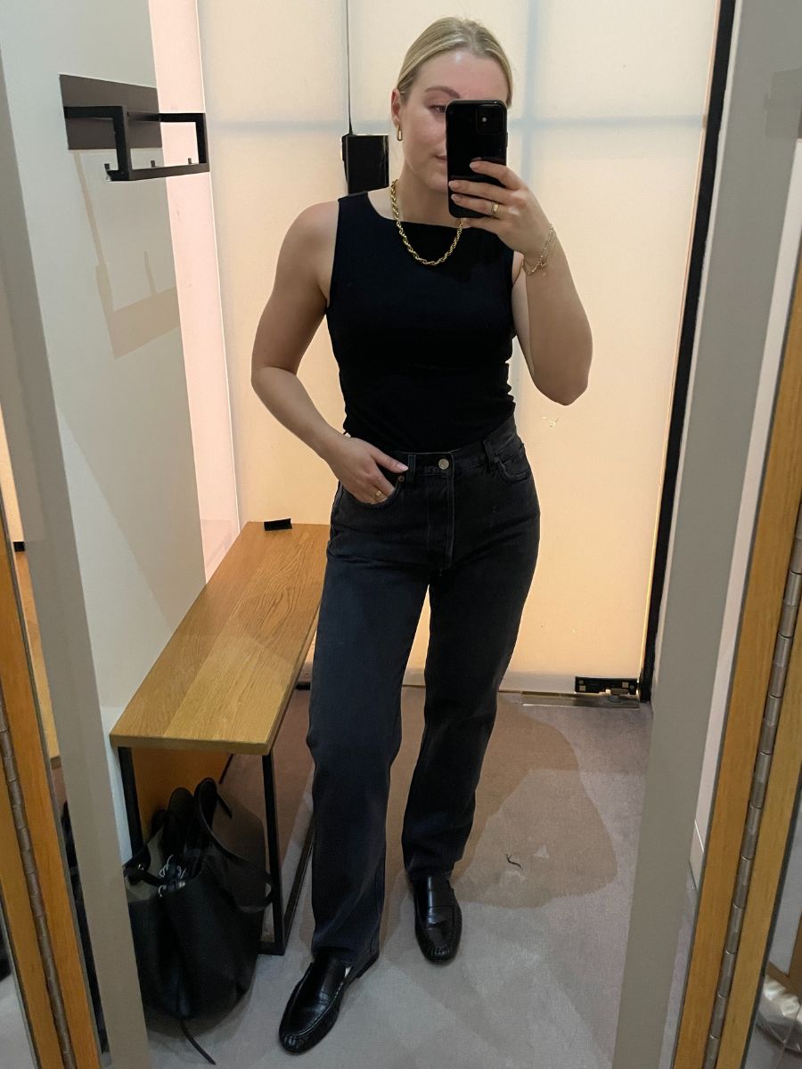 Woman wears black top, black jeans and black loafers