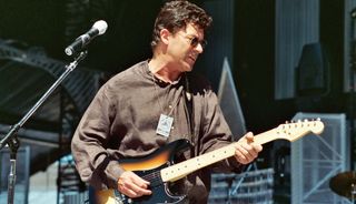 Robbie Robertson performs onstage at the Rock and Roll Hall of Fame Museum in Cleveland, Ohio in 1995