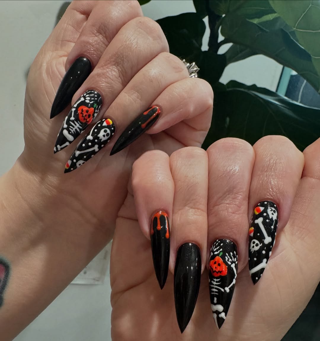 halloween nail art with a black base and white skeleton bones