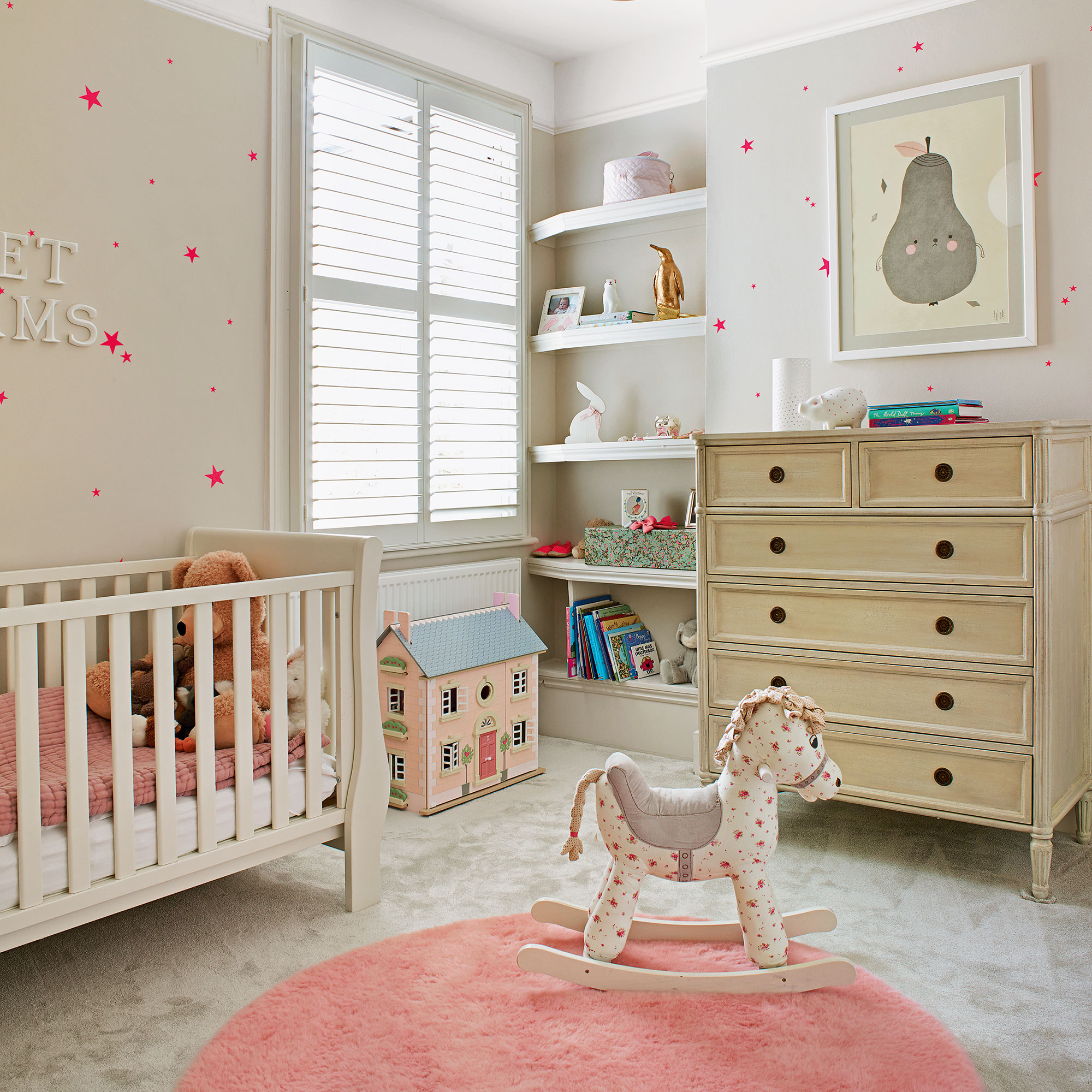 White, grey and pink nursery with bright pink stars on the wall and a round pink rug