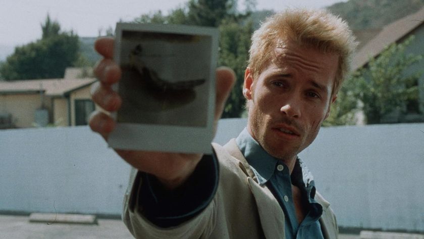 Leonard Shelby holds a polaroid image up to the camera in Memento
