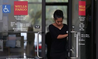 A customer leaves a Wells Fargo Bank branch office July 12