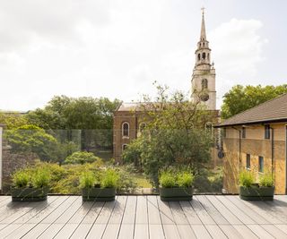 A balcony next to a kitchen overlooking St John's square