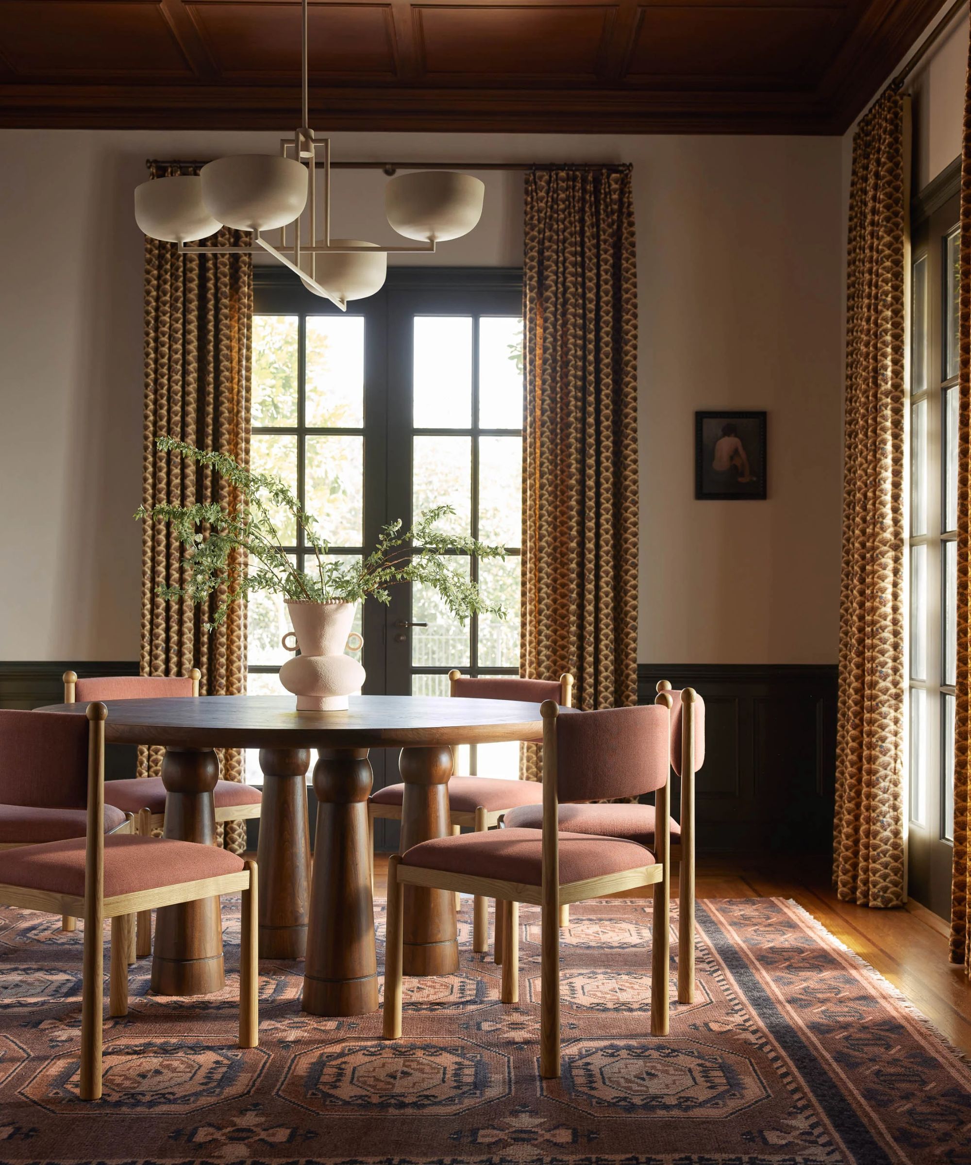 A large dining room with a round table and a vintage style rug