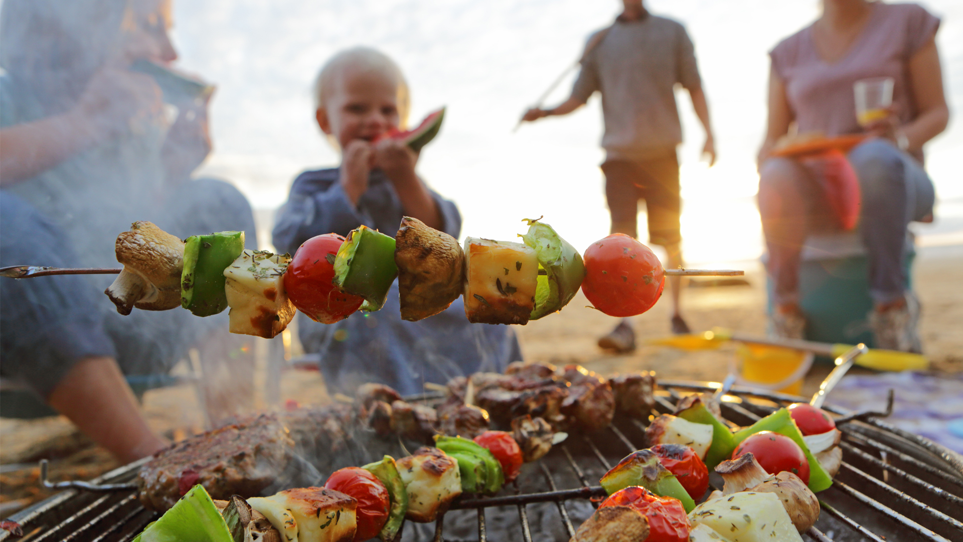 Gas vs charcoal grill: image of toddler eating from BBQ