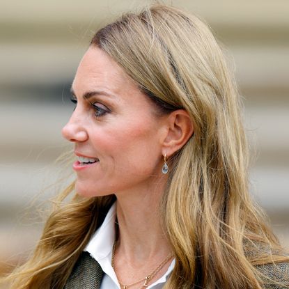 Kate Middleto smiling and turning her head to the side in front of a staircase