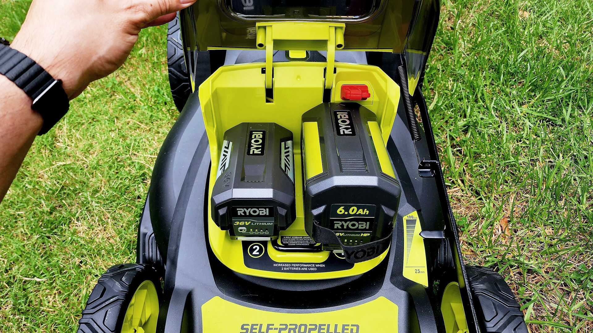 Ryobi 36V HP 46cm 6.0Ah Brushless Cordless Lawn Mower on a lawn with street in the background