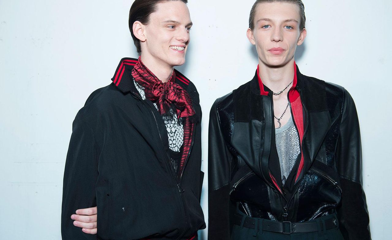 2 male models wearing black &amp; red clothing, smiling at the camera