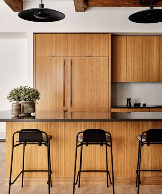 A wood kitchen with black countertops