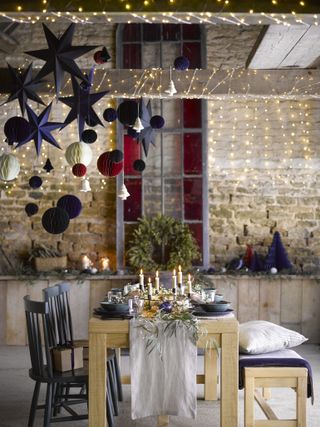 Christmas dining room decor with paper decorations and fairy lights by Garden Trading