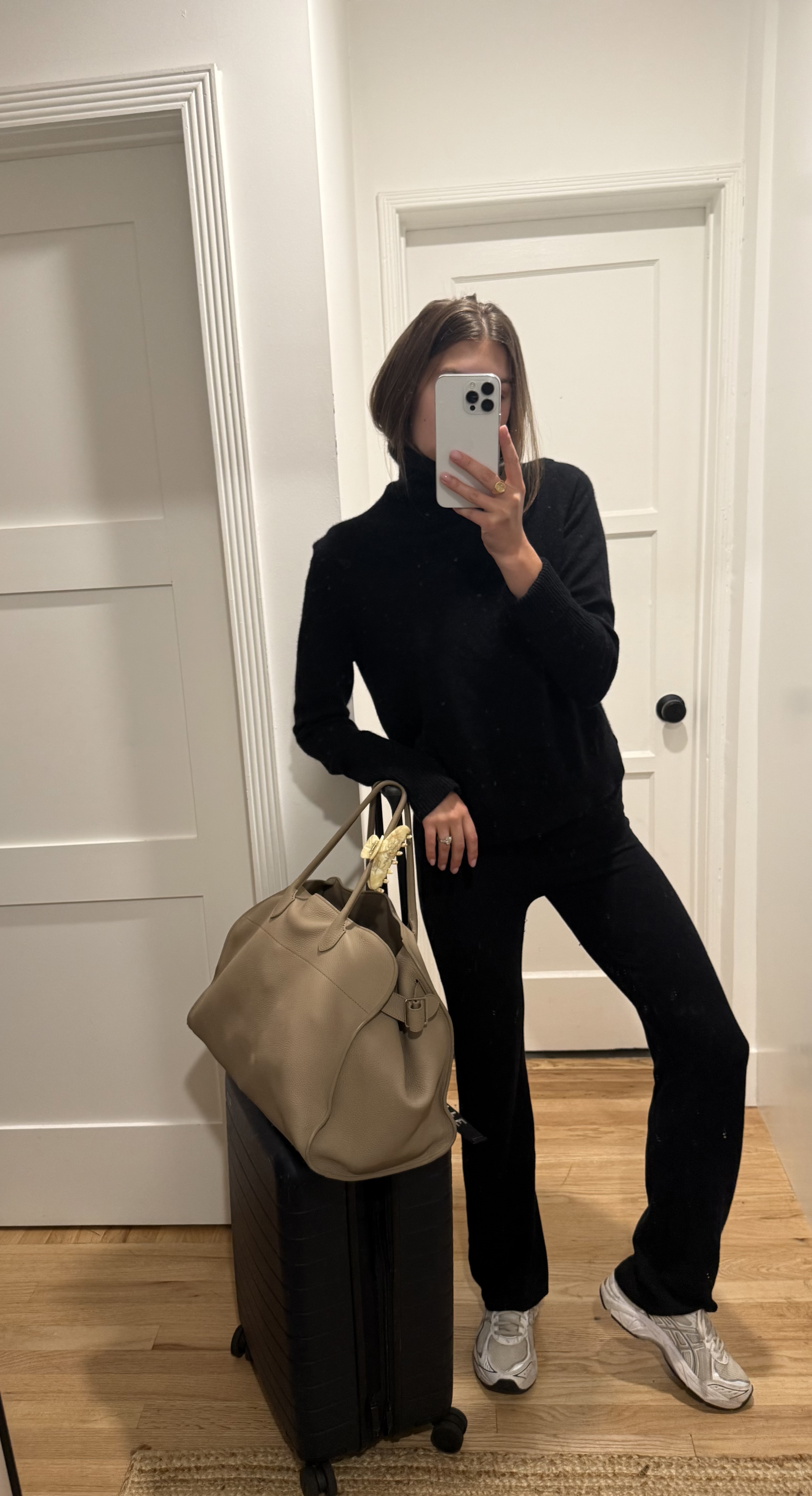 Woman in a black sweater, black pants, and travel bags