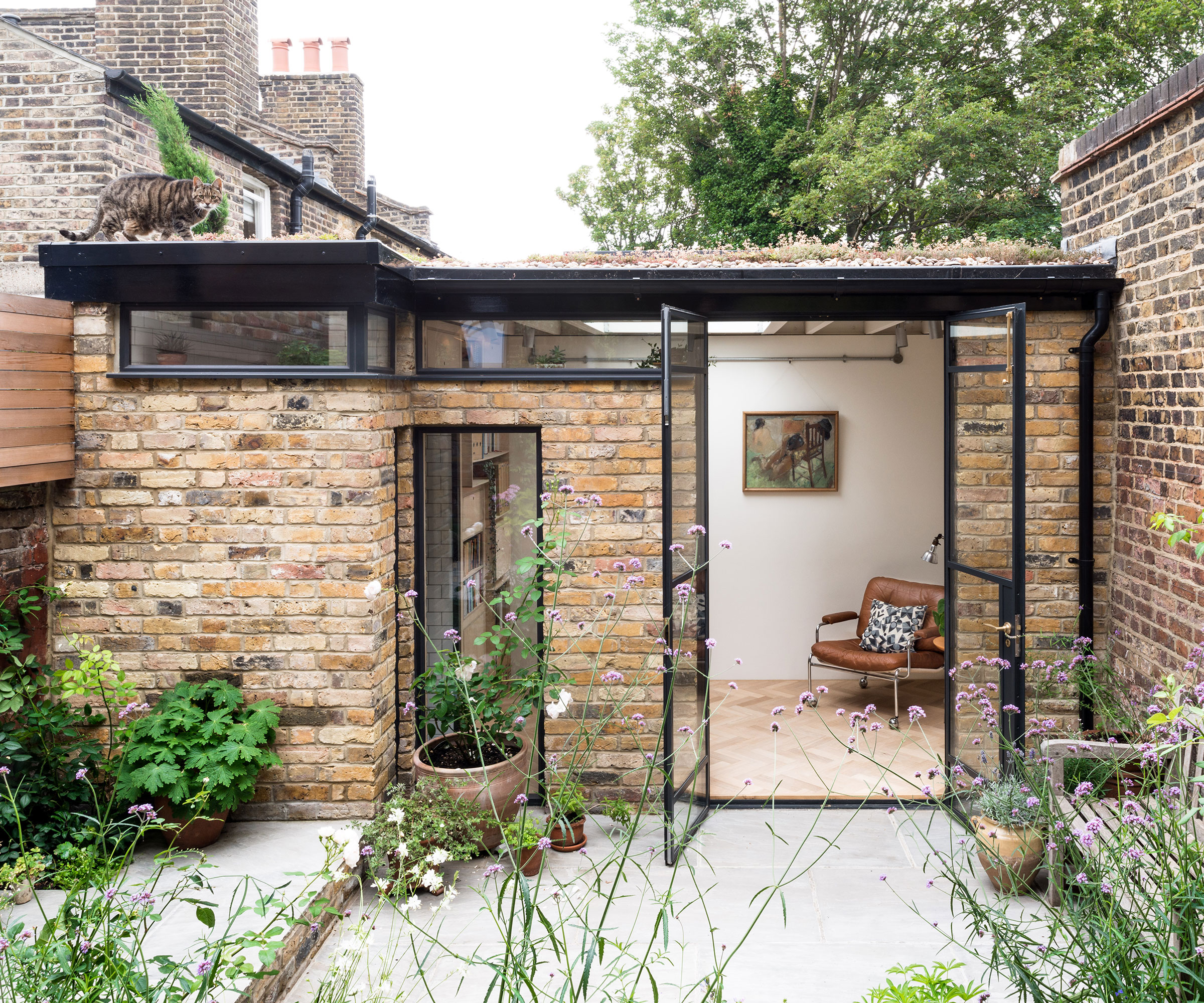 garden studio with reclaimed bricks and a sedum roof