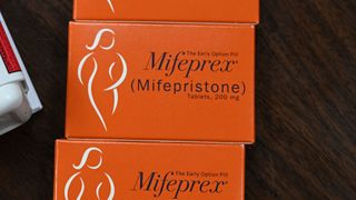 close up of a orange box labeled "the early option pill Mifeprex"