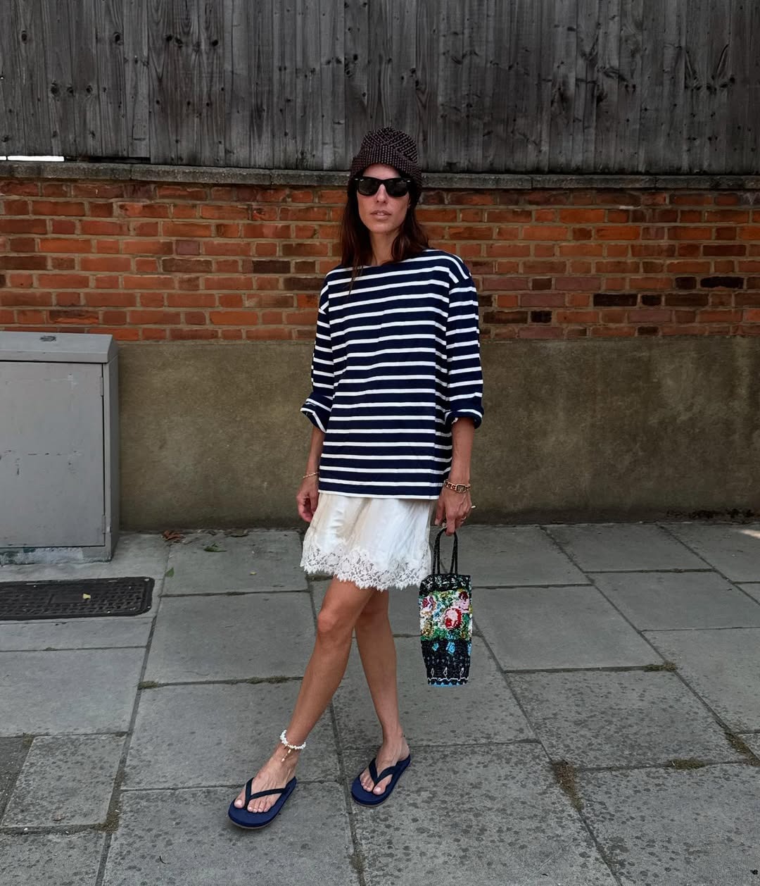 Influencer Laura wears a lace-trim skirt and a blue and white striped shirt with flip-flops.