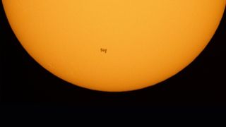 This photo shows the International Space Station as it begins its traverse across the sun's disk as seen by NASA photographer Joel Kowsky on June 25, 2021.