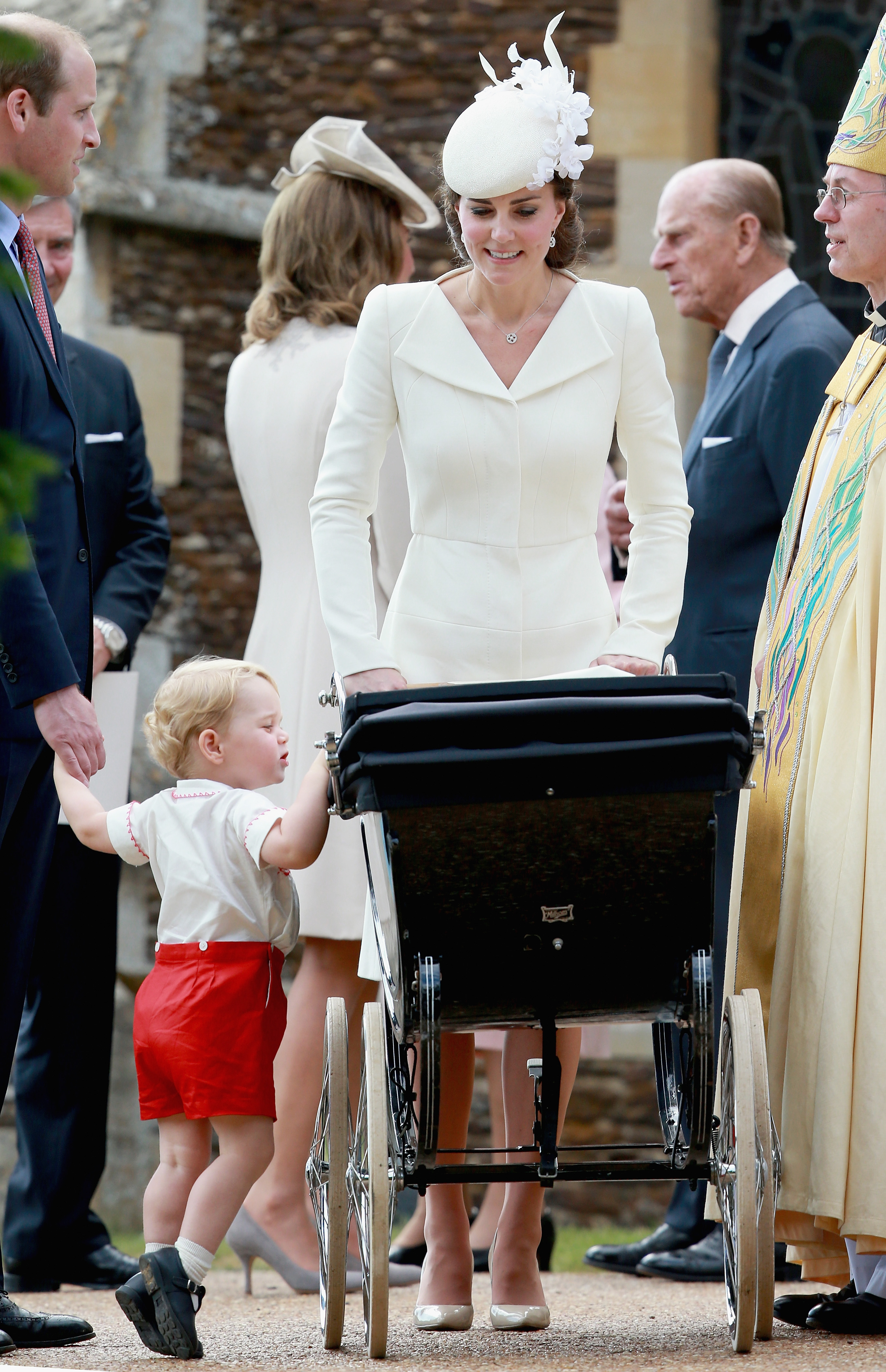 Princess Kate pushing a stroller with Prince George looking inside