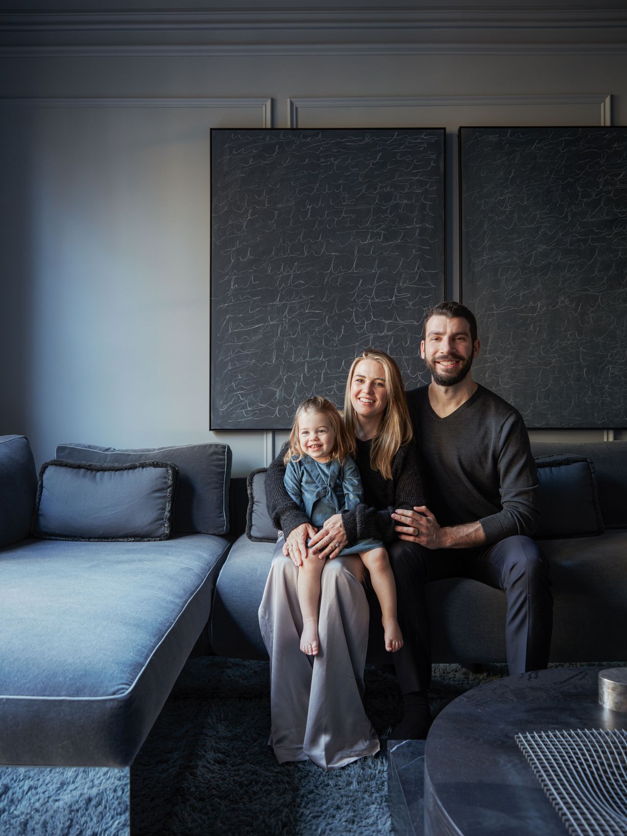 a family sat in a dark gray living room